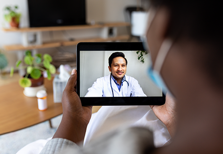 A patient looking at a doctor on a tablet