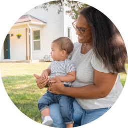 mother sitting on lawn holding child