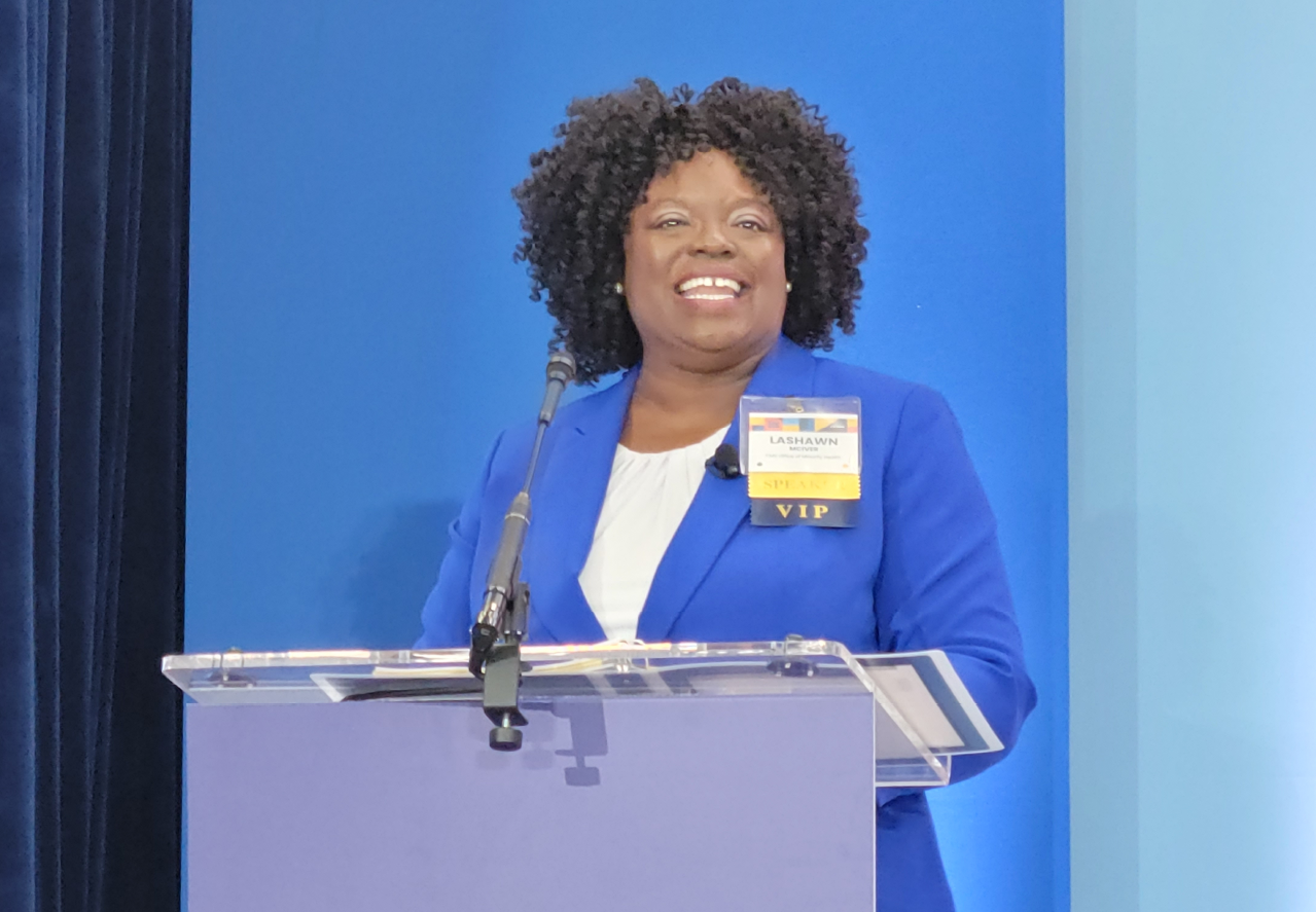 Woman standing at a podium giving a speech