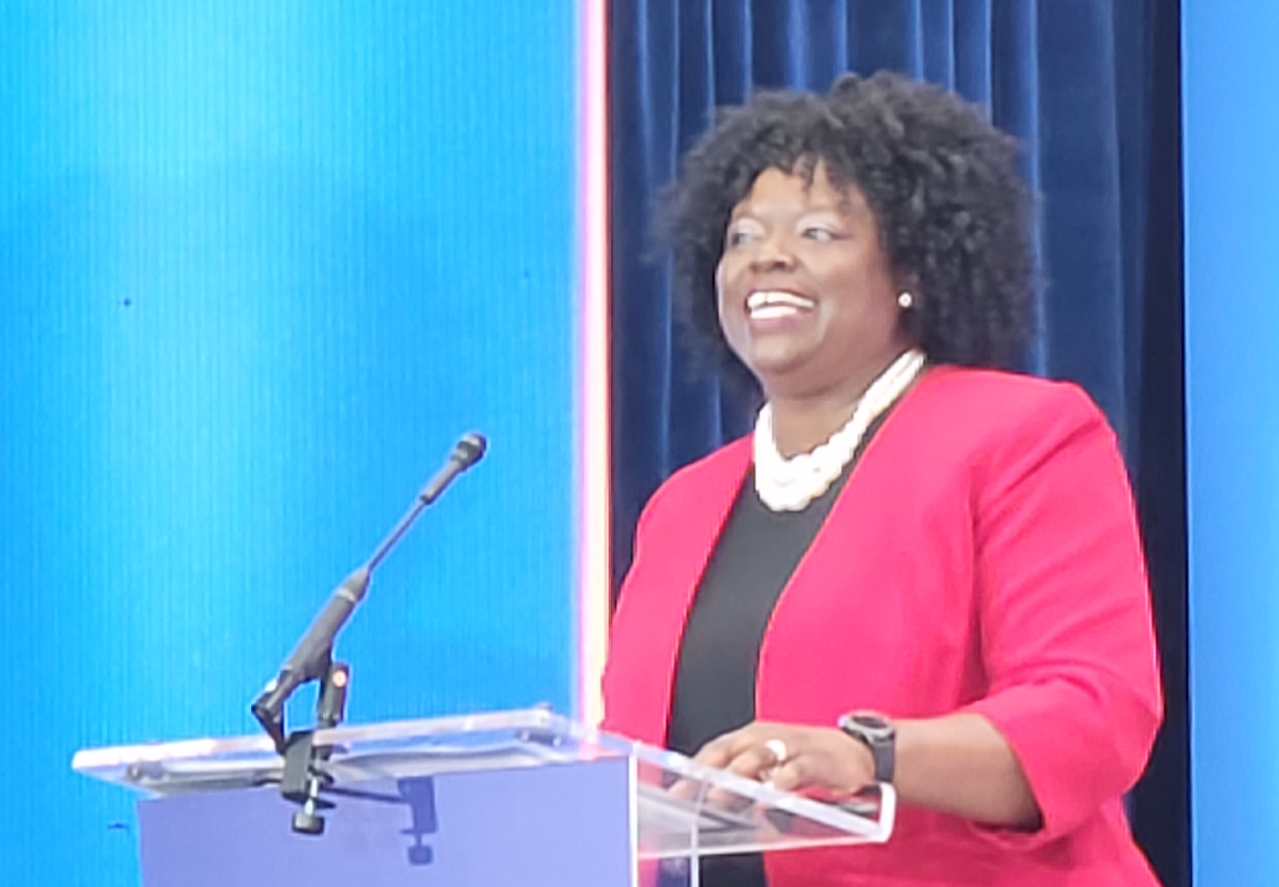 Woman standing at a podium giving a speech