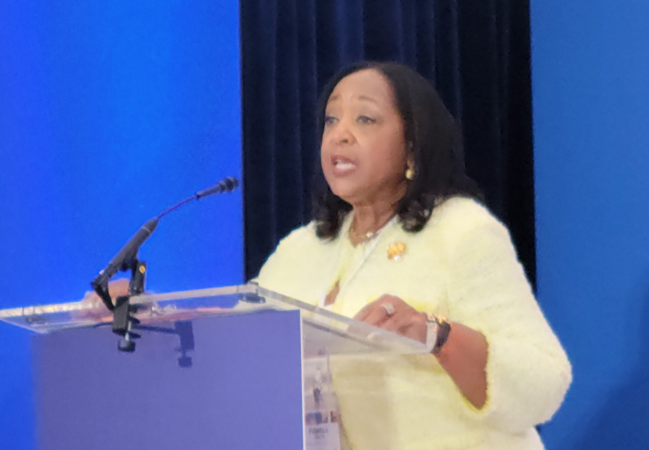 Woman standing at a podium giving a speech