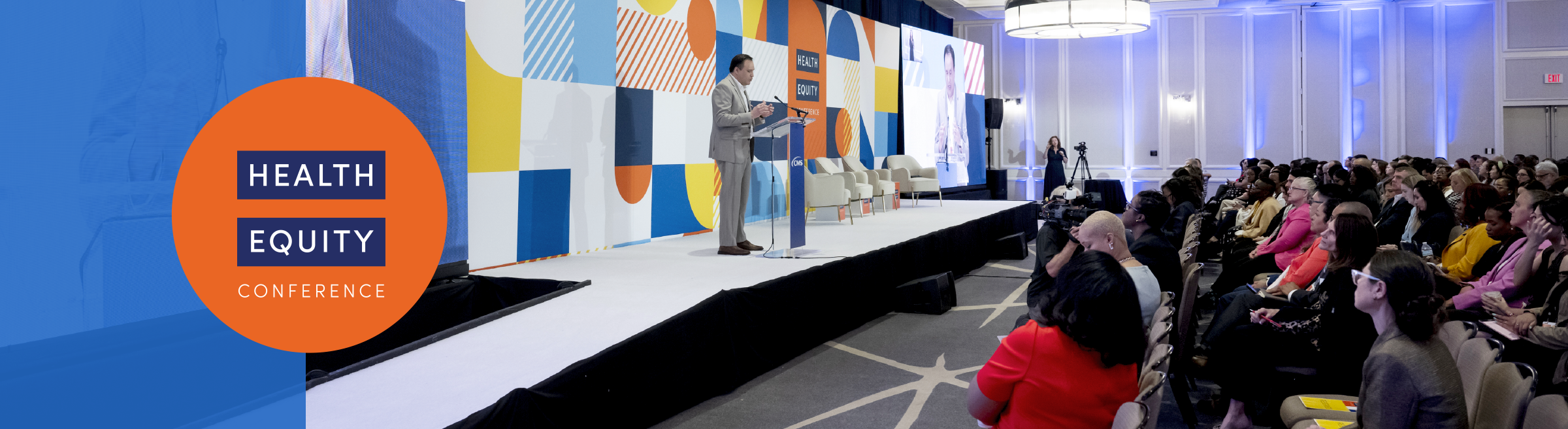 Man speaking the podium while audience listens