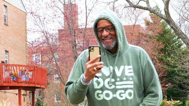 Image of Lamont Mitchell walking outside, smiling, speaking on his cell phone to his care team