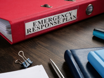 Emergency response plan in a red binder on a desk