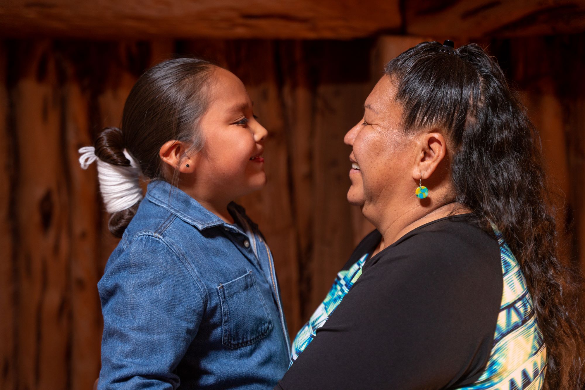 A young native American girl and her grandmother embrace