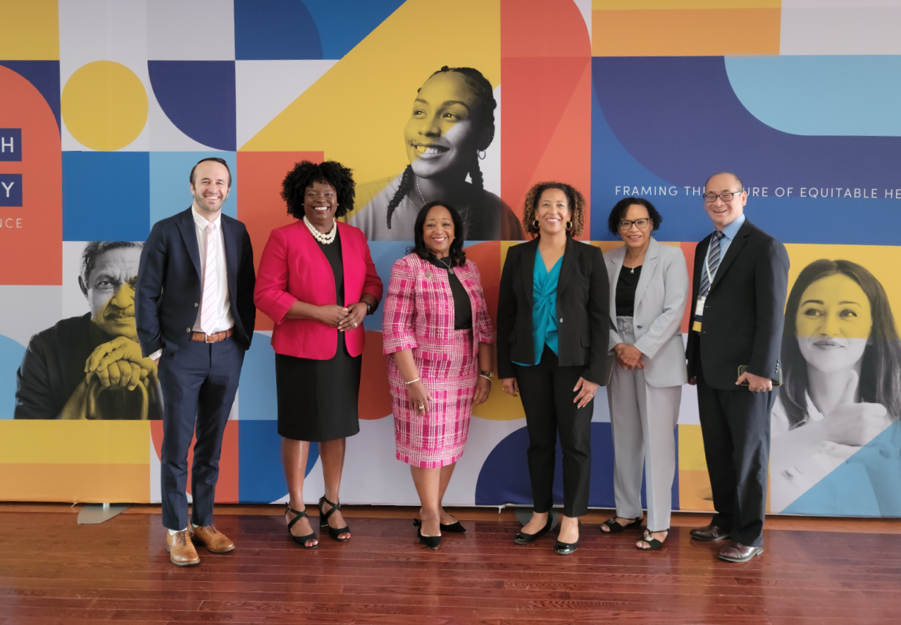 Photo of 6 people standing in front of a wall at the CMS Healt Equity Conference 