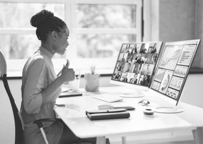 Black and white image of women presenting in front of two screens